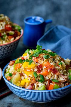 two bowls filled with rice and vegetables on top of a table