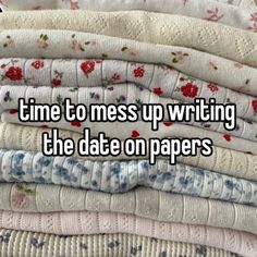 a stack of folded clothes with the words time to mess up writing the date on papers