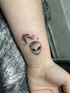 an alien tattoo on the wrist