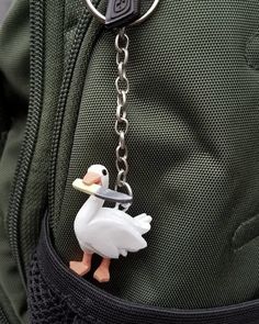 a keychain with a duck holding a piece of food in it's mouth