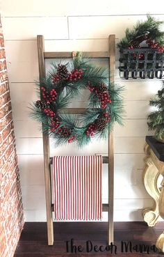 a christmas wreath is hanging on the wall next to a chair and other decor items