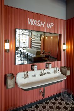 a bathroom with a sink and mirror on the wall next to a red striped wall