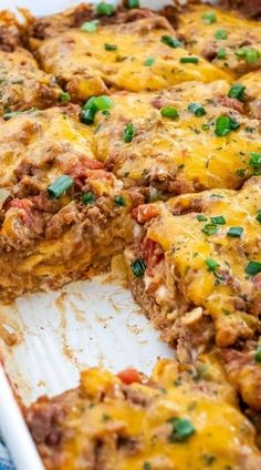 a casserole with meat, cheese and green onions on top is cut in half