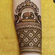 henna tattoo on the leg of a woman with an elephant and flower motif in it