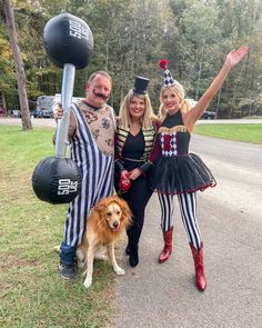 three people and a dog posing for a photo