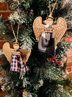 an angel ornament hanging on a christmas tree in front of a brick wall