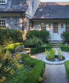 a house with a garden in front of it and a stone walkway leading to the front door