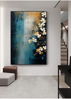 an abstract painting hangs on the wall in a modern living room with white and gold accents