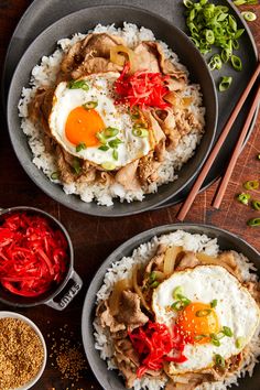 two bowls filled with rice, meat and fried eggs