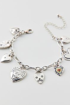 Vintage-inspired charm bracelet trimmed with a mix of heart-shaped charms. Choose from a silver or gold bracelet. Features Kyla heart charm bracelet Vintage-style charm bracelet Adjustable length Content + Care Mixed metal, glass Avoid contact with water Imported Size Dimensions: 7.5" l + extender | Kyla Heart Charm Bracelet in Silver, Women's at Urban Outfitters Charm Bracelet Aesthetic, Bracelet In Silver, Vintage Charm Bracelet, Silver Charm Bracelet, Bracelet Vintage, Mixed Metals, Heart Charm Bracelet, Silver Bracelets, Silver Charms