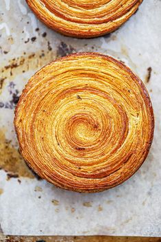 two pastries sitting on top of a piece of parchment paper next to each other