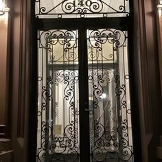 an ornate iron door with glass panels on the front and side doors, in a building