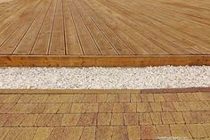 a close up of a wooden deck with gravel