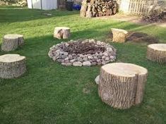 a fire pit made out of logs in the grass