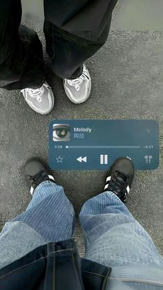 two people standing next to each other with their feet on the ground and one person holding an mp3 player