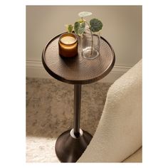 a small table with a vase and candle on it