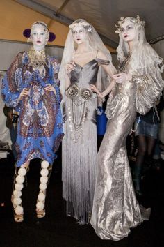 three mannequins are dressed in silver and gold clothing at a fashion show