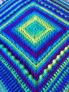 a crocheted blanket is sitting on the floor