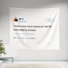 a tweet is displayed on a wall with a plant in the foreground