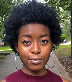 a close up of a person with an afro haircut and large hoop earrings on