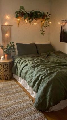 a bed with green sheets and pillows in a bedroom next to a window filled with lights