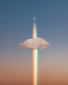 an airplane flying over a rainbow colored cloud in the sky with a star above it