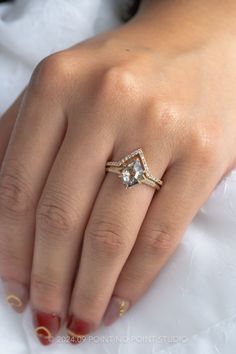 a woman's hand with a ring on it and a diamond in the middle