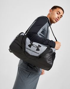 From the court to the gym, keep your training essentials secure in this Undeniable Small Duffle Bag from Under Armour. In a Pitch Grey Medium Heather and Black colourway, this lightweight bag is made from durable poly fabric, with PU-coated & foam-lined bottom and side panels for added protection. Equipped with water-repellent UA Storm tech, it features multiple zippered and vented pockets to organise your wet from dry workout gear, as well as an adjustable shoulder strap. With top handles for easy carry, this bag is finished up with signature UA branding. (L: 55 x H: 25.5 x W: 27cm) Small Duffle Bag, Molle Webbing, Pre Workout Supplement, Post Holiday, Calf Muscles, Fitness Gifts, Sport Earbuds, Lightweight Bag, Holiday Shopping