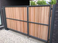 a wooden gate with metal bars on the top and bottom part, in front of a brick building