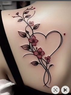 the back of a woman's shoulder with flowers and vines on it, as well as a heart