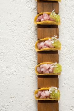 five small food items are arranged on a wooden shelf in the shape of a rectangle