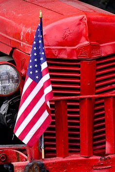 an old red truck with the american flag on it's front grill and hood