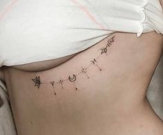 a woman's stomach with stars and moon tattoos on it