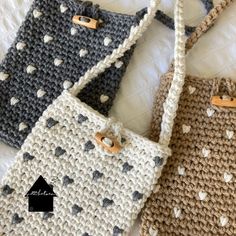 three crocheted purses sitting on top of a bed