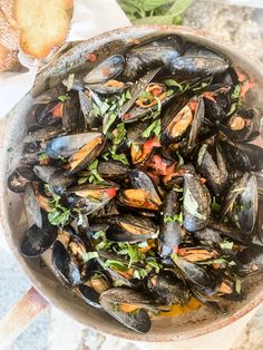 a pan filled with mussels on top of a table