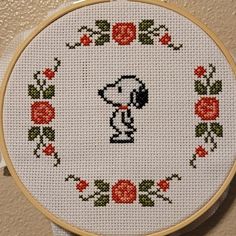 a cross stitched picture of a dog with roses on it's hoop frame