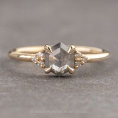 a yellow gold engagement ring with a gray diamond