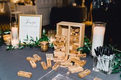 a table topped with lots of wooden blocks and candles