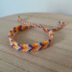 a close up of a bracelet on a wooden surface