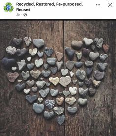 some rocks are arranged in the shape of a heart on a wooden surface with words that read recycled, restored, re - purposed