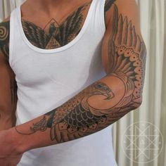 a man wearing a white tank top with an eagle tattoo on his arm and chest