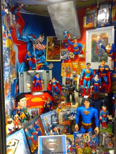 a bunch of action figures are on display in a room with many pictures and toys