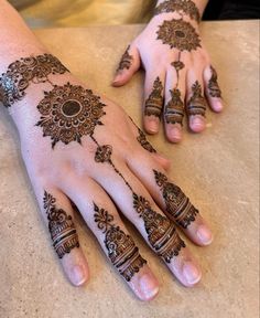 two hands with henna tattoos on them