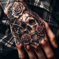 a person with a tattoo on their hand holding a skull and roses