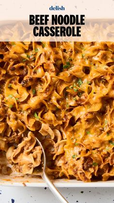 beef noodle casserole in a white dish with a serving spoon on the side