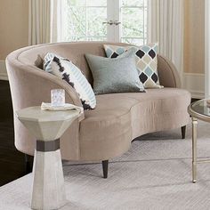 a living room filled with furniture and pillows on top of a white carpeted floor