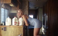 a woman leaning on a counter with milk in front of her