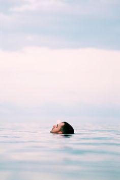 a man floating in the ocean with his head above water