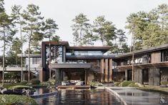 a large house with lots of windows and water in front of it, surrounded by trees