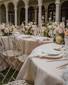 the tables are set with white and pink flowers